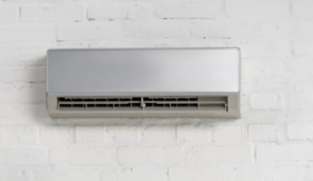 Climatiseur mural installé sur un mur blanc